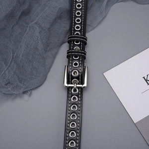 Detail of black grommet belt featuring double row silver eyelets and white stitching