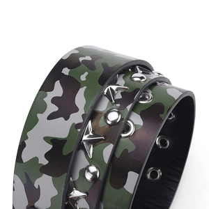 Détail d'une ceinture camouflage avec clous en étoile argentés et œillets au style punk