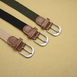 Close-up of three woven elastic belts in olive green, black, and beige with leather ends