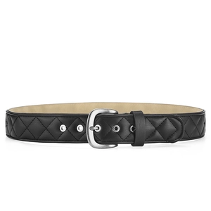 Détail d'une ceinture en cuir matelassé noir avec motif losanges et boucle argentée