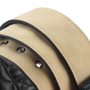 Détail de la ceinture en cuir beige avec œillets métalliques et bords noirs polis