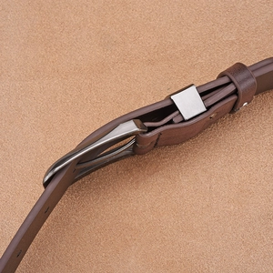 Close-up of brown leather belt with gunmetal pin buckle showing texture and stitching details