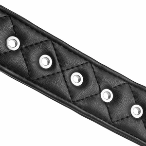 Détail d'une ceinture en cuir noir avec surpiqûres en losanges et œillets en métal argenté