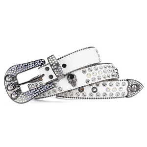 Close-up of white crocodile leather belt with skull ornaments and crystal rhinestones