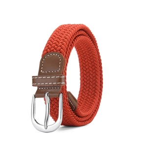 Detail of orange elastic woven belt with silver pin buckle and brown leather trim
