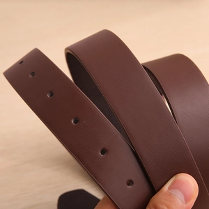 Close-up of deep brown leather belt showing fine grain texture and round buckle holes