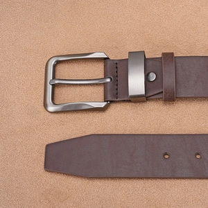 Close-up of brown matte leather belt featuring a gunmetal brushed metal buckle