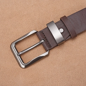 Detailed close-up of dark brown leather belt with gunmetal brushed pin buckle