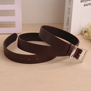 Detail of dark brown leather belt with silver rectangular buckle and adjustable holes on wood