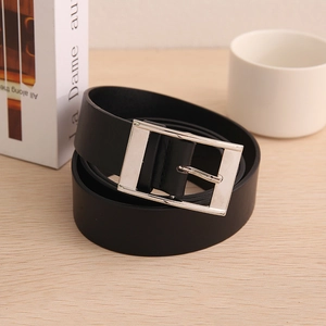 Men's black leather belt with silver square pin buckle on a wooden surface