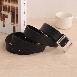 Men's minimalist black leather belt with rectangular silver metal buckle on wood background