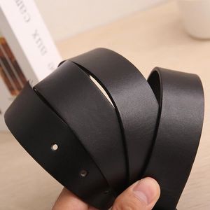 Detail of black lychee texture leather belt with neat holes on light wooden surface