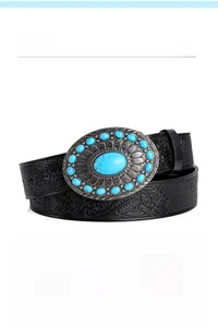 Detail of bohemian black embossed leather belt with oval turquoise alloy buckle
