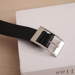 Detail of classic black leather belt showing polished silver rectangular alloy pin buckle