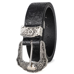 Detail view of Western style black leather belt with floral embossing and carved silver buckle