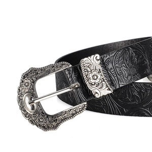 Detail of western floral embossed black leather belt with ornate silver carved buckle