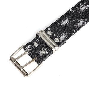 Close-up of black denim belt with silver metal double pin buckle and punk star studs