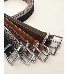 Detailed macro view of vintage belts in various colors and patterns with square silver buckles