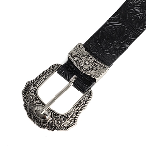Detail of western style belt with vintage floral carving on silver buckle and embossed leather