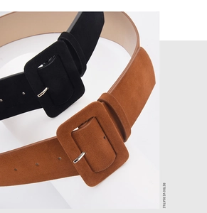Detail of suede waist belts featuring large fabric-wrapped square buckles in black and brown