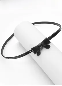 Détail d'une fine ceinture en similicuir noir avec un nœud double et des œillets en métal