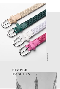 Dettaglio delle cinture intrecciate elastiche beige, verdi, bianche e rosa con fibbie ad ago