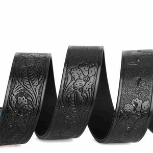 Close-up of bohemian black leather belt with detailed vintage floral embossed texture