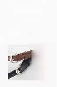 Gros plan de ceintures minimalistes en similicuir noir et marron avec boucle argentée