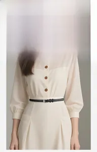 Détail d'une fine ceinture noire en similicuir avec boucle argentée sur robe beige