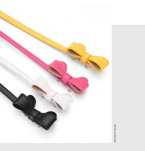 Détail de ceintures fines colorées dotées d'élégantes boucles en nœud en quatre couleurs