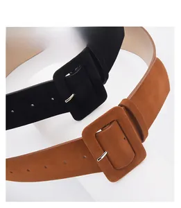 Close-up of black and brown suede wide belts with large square buckle details