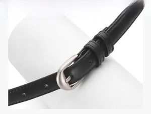Détail d'une ceinture en cuir PU noir avec boucle argentée mate et finitions soignées