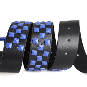 Detail view of black punk belt featuring three rows of blue square pyramid studs