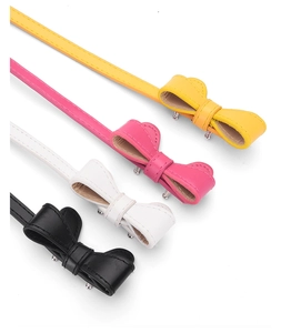 Détail de fines ceintures en cuir PU avec boucles nœuds en jaune, rose, blanc et noir