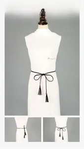 Détail de la ceinture en corde noire tressée avec glands et perles décoratives brun-rouge