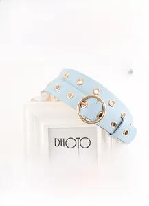 Détail de la ceinture en cuir PU bleu clair avec boucle dorée ronde et œillets en métal