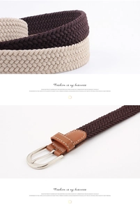 Detail of woven elastic belt texture with PU leather trim and silver metal buckle