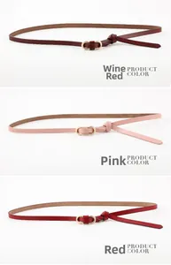 Détail de ceintures fines en cuir bordeaux, rose et rouge avec boucle dorée à double anneau