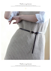 Détail d'une fine ceinture en cuir avec boucle dorée à double anneau sur une robe
