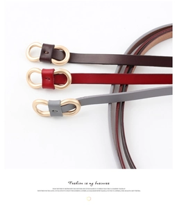 Détail de ceintures fines en marron, rouge et gris avec des boucles métalliques dorées en huit