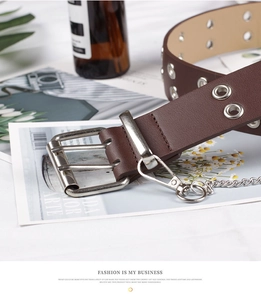 Detail of dark brown leather punk belt with double silver eyelets and metal chain