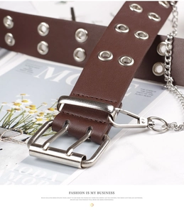 Close-up of brown punk belt with silver double grommets and detachable metal chain