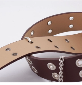 Close-up of dark brown punk belt with double metal eyelets and silver chain detail