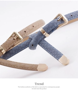 Détail de ceintures fines motif serpent avec boucles en métal doré en bleu et beige