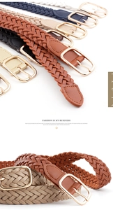 Detail of woven women's skinny belt with golden horseshoe buckle and textured braid