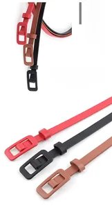 Detail of slim patent leather belts for women in red black and brown with covered buckles