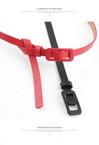 Close-up of thin red and black patent leather belts with matching leather-wrapped buckles