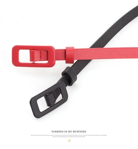Detail of red and black patent leather skinny belts with matching square wrapped buckles