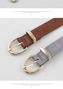 Dettaglio di cinture in pelle con motivo a coccodrillo marrone e grigio e fibbie oro