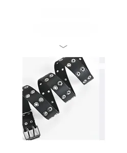 Détail de la ceinture en cuir noir avec double rangée d'œillets argentés et une boucle à double ardillon